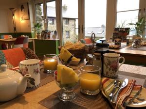a table with a breakfast of cheese and orange juice at The Old Farmhouse B&B in Dyffryn