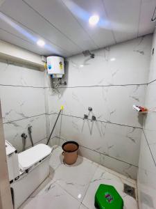 a bathroom with white marble walls and a toilet at Hotel Shankar Gaura Palace in Ujjain