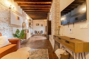 a living room with a couch and a tv on the wall at Apartamento San Bartolome Albaicin in Granada