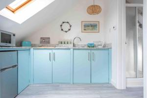 a kitchen with blue cabinets and a sink at A cosy hideaway on the Jurassic Coast in Lyme Regis