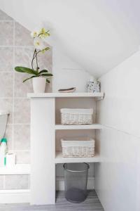 Un estante blanco con una planta en un baño. en A cosy hideaway on the Jurassic Coast, en Lyme Regis 11 fotos más
