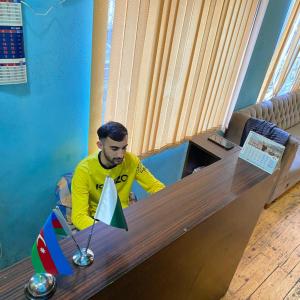 a man is sitting at a table with a toy flag at Shaan E Punjab HOSTEL in Baku