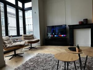 a living room with a fireplace and a flat screen tv at Villa Frans Luxe appartement 4 slpk in Ostend