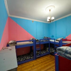 a room with blue and pink walls and bunk beds at Shaan E Punjab HOSTEL in Baku