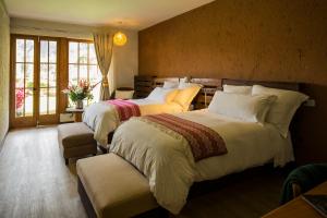 1 dormitorio con 2 camas y ventana en Lamay Lodge, en Cusco