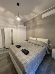 um quarto com uma cama com duas toalhas pretas em Maison Cristina em Lido di Ostia