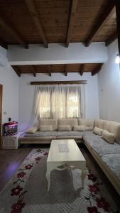 uma sala de estar com um sofá e uma mesa em Idili Historik i Kodrës em Berat
