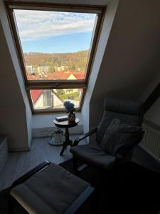 a living room with a chair and a large window at Ferienwohnung „Ruppbergblick“ in Zella-Mehlis