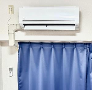 a air conditioner on a wall next to a curtain at Purezant - Vacation STAY 37459v in Orio
