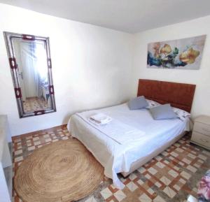 een slaapkamer met een bed met een spiegel en een tapijt bij small villa with garden close to the beach in Temara
