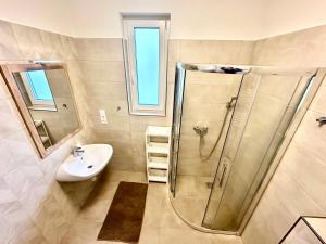 a bathroom with a shower and a sink at Ady Corner Prémium Apartmanok - Siófok in Siófok +32 photos