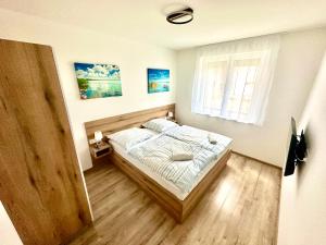 a bedroom with a bed and a window at Ady Corner Prémium Apartmanok - Siófok in Siófok