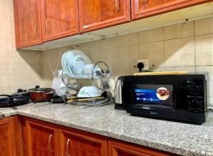 a microwave on a counter in a kitchen at Dubai Homes near ADCB METRO STATION in Dubai