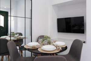 a dining room with a table with chairs and a tv at Lusso di Campiello in Corfu Town