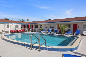 uma piscina num hotel com cadeiras e um edifício em Sun Island Motel em St. Pete Beach