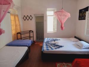 a bedroom with two beds and a window at Piyanivasa in Ambalangoda +22 photos