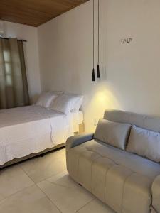 - une chambre avec un lit et un canapé dans l'établissement Serra Chalés, à Serra de São Bento