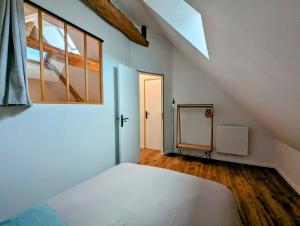 Zimmer im Dachgeschoss mit einem Bett und einem Spiegel in der Unterkunft Charmante maison 6 pers, proche Loire à vélo in Suèvres