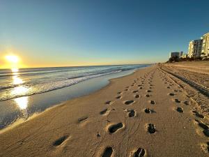 a beach with footprints in the sand and the ocean at Diamond Crest Motel in Wildwood Crest