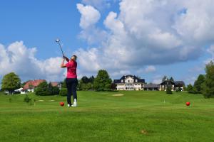 a woman is playing golf on a golf course at 17er Apartment mit Sauna und Garage in Mondsee