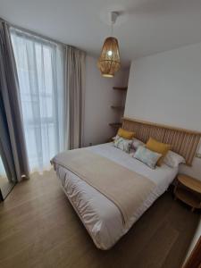 a bedroom with a large bed with a large window at Apartamentos Puerto Camariñas in Camariñas