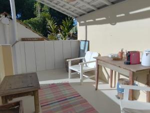 un patio con una mesa de madera y un banco de madera en Pousada Sol da Manha QUADRADO, en Trancoso