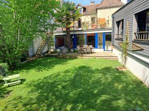 una casa con un patio con césped sidx sidx sidx sidx en La maison des sources, en Hérouville-Saint-Clair