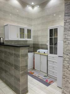 a kitchen with white cabinets and white appliances at شاليهات السلطان - العلا in AlUla