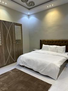 ein Schlafzimmer mit einem großen Bett mit weißer Bettwäsche in der Unterkunft شاليهات السلطان - العلا in Al-'Ula