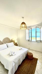 a white bedroom with a large bed and a chandelier at Oltremare Suite N37 Villa fronte mare con spa privata giardino vista panoramica e wifi gratuito in Bagheria +73 photos