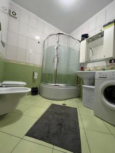 een badkamer met een douche en een wasmachine bij Reka Apartment in Tirana