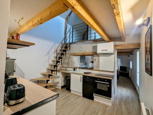uma cozinha com armários brancos e uma escada em espiral em Charmante maison 6 pers, proche Loire à vélo em Suèvres