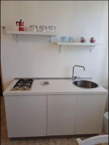 uma cozinha branca com um lavatório e um fogão em Masseria Marciane em Uggiano la Chiesa