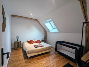 um quarto com uma cama e uma janela num sótão em Charmante maison 6 pers, proche Loire à vélo em Suèvres