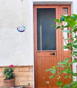 una puerta de madera de una casa con un cartel en Ortensia Apartment, en Giungano