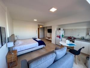a bedroom with a bed and a living room with a kitchen at Fk Alojamientos Liniers in Buenos Aires