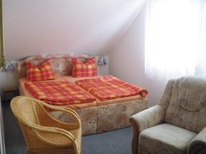 Bett in einem Zimmer mit Sofa und Stuhl in der Unterkunft Ferienwohnung Teutschenthal OT Langenbogen in Teutschenthal