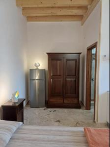 um quarto com um frigorífico e um armário de madeira em Masseria Marciane em Uggiano la Chiesa
