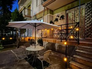 a table and chairs with an umbrella on a patio at Casa Planet Rapallo in Rapallo
