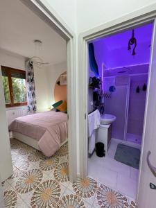 a bedroom with a purple room with a bed and a bathroom at Casa Planet Rapallo in Rapallo