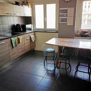 a kitchen with a table and two stools at Chambre cœur du centre-ville in Le Havre