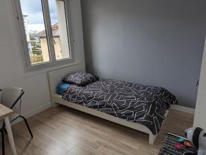 a small bedroom with a bed and a window at Chambre cœur du centre-ville in Le Havre