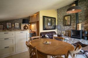 a kitchen and living room with a wooden table and chairs at La Bergerie du Haut Var in Bargème