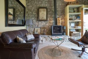 a living room with a leather couch and a fireplace at La Bergerie du Haut Var in Bargème