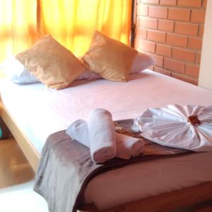 een bed met handdoeken en 2 handdoeken bij Mi pueblo natal Aptos y habitaciones in Necoclí