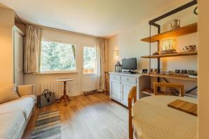 1 dormitorio con cama, escritorio y ventana en Alpes Bellevue furnished flat, en Les Houches