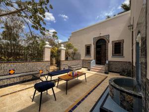 un patio con mesa y sillas y un edificio en Villa Octavia en Mérida