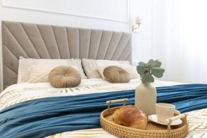 a bed with a basket of bread and a vase on it at We Home - Prada Luxury Suites [Milan] in Milan