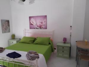 Un dormitorio con una cama verde y una mesa en Cerroni's corner CISE 29636, en Roma