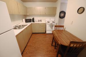 a kitchen with a table and a sink and a stove at Paris Plaza in Elliot Lake